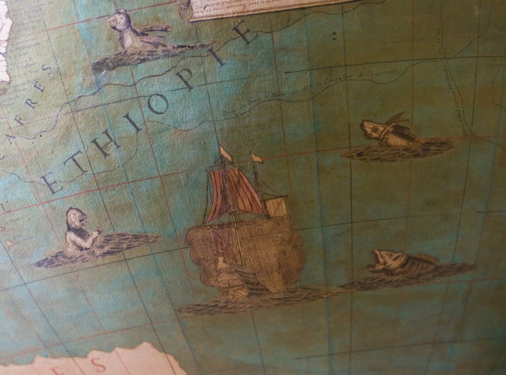 Photographie d'un bateau tirant au canon et de monstres marins.
